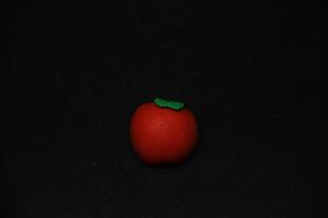 redondo tomate conformado borrador estacionario herramientas para oficina o colegio suministros. aislado foto en llanura oscuro negro antecedentes.