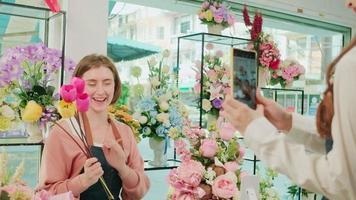 E-Commerce Geschäft Partner, jung Weiß weiblich Florist demonstriert und zeigt an Blumen- Vereinbarungen über online Leben Streaming durch Smartphone Anwendung im hell Blume Geschäft, schön Blüten speichern. video