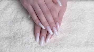 hermosa profesionalmente cuidado hembra manos con pintado en blanco color uñas video