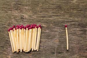 Matches on wooden background. Concept of loneliness, allocation from crowd. photo