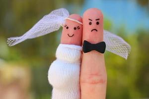 Fingers art of couple. Concept of shotgun wedding. Man was upset because woman is pregnant and he needs to get married. photo