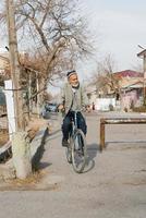 Bukhara, Uzbekistan. December 2021. A resident of Bukhara, an elderly Uzbek man rides a bicycle around the city photo