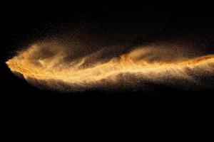 Brown colored sand splash.Dry river sand explosion isolated on black background. photo