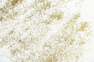 Festive or glamorous background. Gold sparkles scattered on a white background. photo