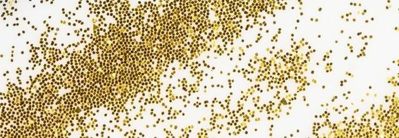 Festive or glamorous background. Gold sparkles scattered on a white background. photo