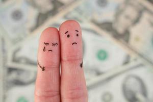 Fingers art of displeased couple on background of money. Concept of poor people. photo