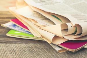 Newspapers and magazines on old wood background. Toned image. photo