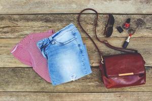 Women's summer clothing and cosmetics on old wooden background. Toned image. photo