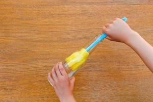 Female hands washing bottle brush. photo