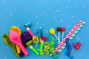 Candy, whistles, streamers, balloons on holiday table. Concept of children's birthday party. View top. photo