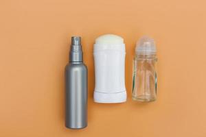 Different deodorants on beige background. Top view. photo