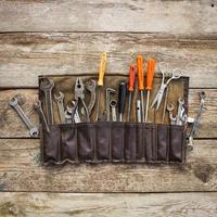 Old tools in a bag on wooden background. Top view. photo