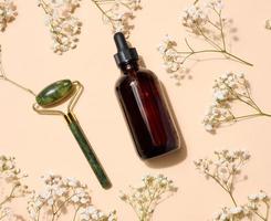 A glass brown bottle with a dropper on a on beige background, a container for cosmetic products photo