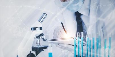 biochemical research scientist working with a microscope for the virus,Doctor man write a history of the experimental results in a , laboratory glassware containing chemical liquid for design. photo