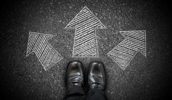 Black Business Shoes and Three Geometrical Chalky Arrows on Asphalt - Choice Concept photo