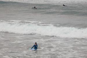 joven Atletas practicando el agua deporte de surf foto