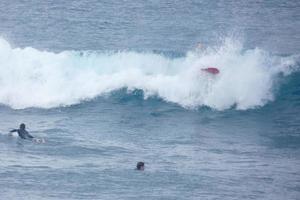 Surfers riding small ocean waves photo