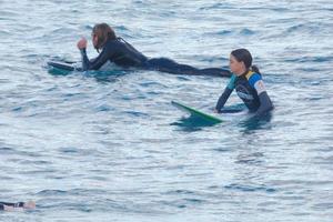 Surfers riding small ocean waves photo