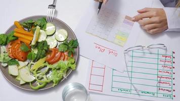 en bonne santé fruit, légume, correct nutrition et régime concept. diététicien. le diététicien médecin écrit une régime plan sur le tableau. nutritionniste travail dans le bureau. video