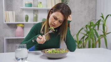 vegetabiliska diet. de kvinna gör inte tycka om grönsaker. de kvinna vem följer en vegetabiliska diet gör inte äta de sallad och gör inte tycka om grönsaker. video