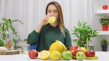 Dieting woman consumes healthy foods. The woman who drinks orange juice eats healthy and is happy. video