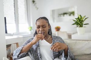 Young African woman holding self testing self-administrated swab and medical tube for Coronavirus covid-19, before being self tested at home photo