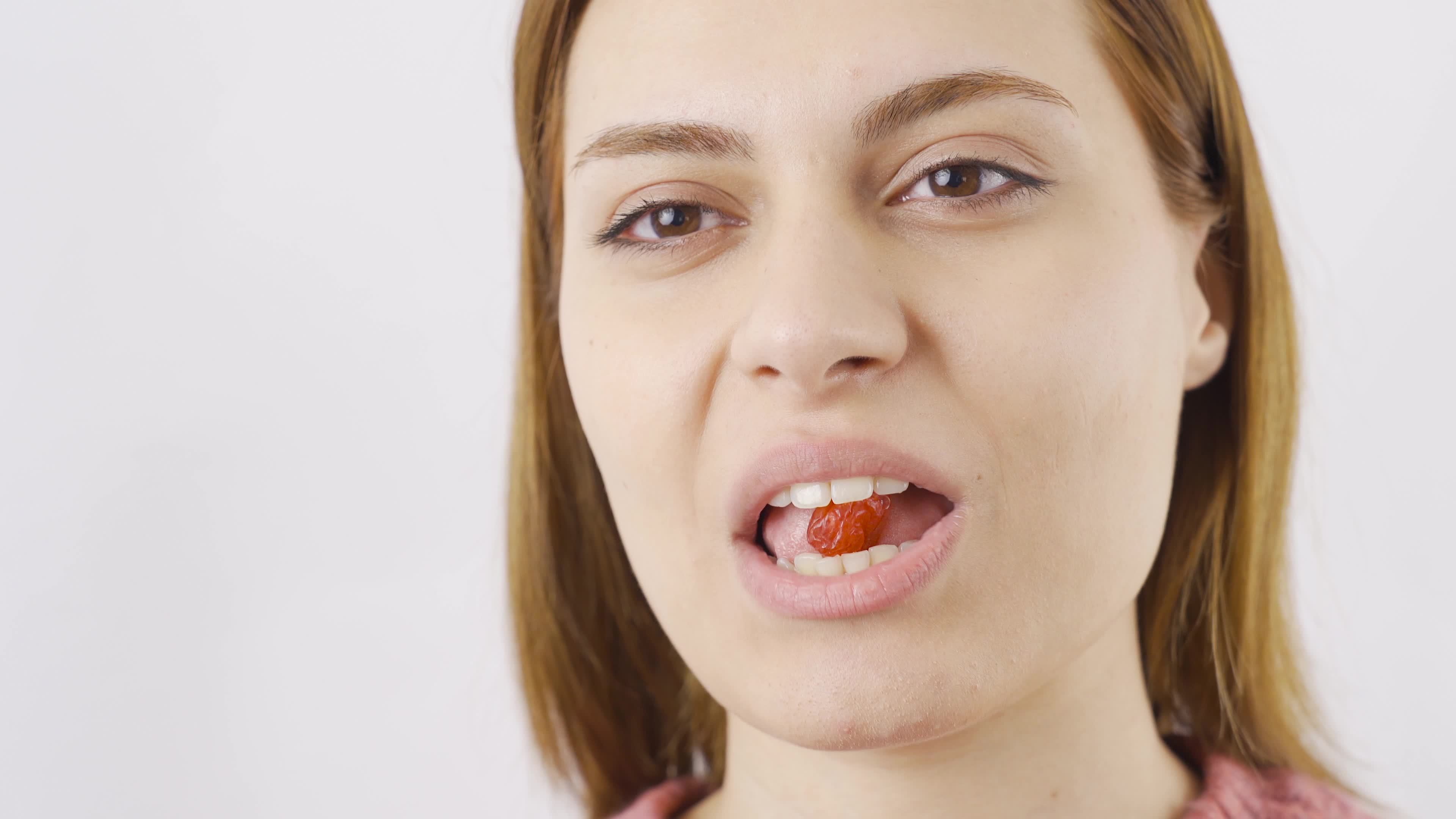 Woman eating dried apricots in closeup. Dry fruits. Closeup woman