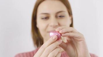 Woman eating chocolate with heart in close-up. Eating chocolate. Close-up woman eats heart shaped chocolate. video