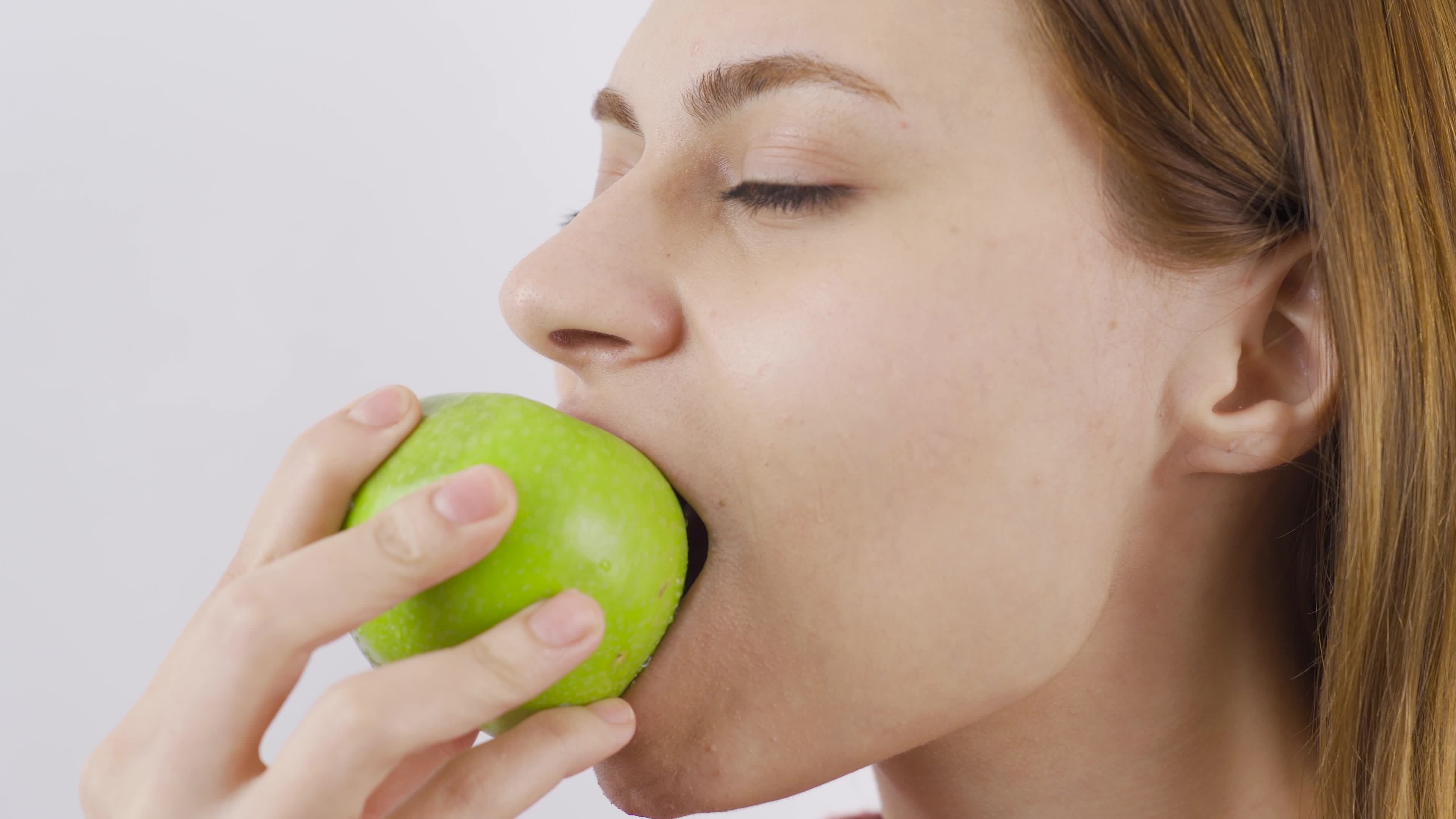 Closeup portrait of woman eating green apple. Eat fruit. Closeup of