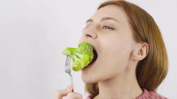 detailopname portret van vrouw aan het eten broccoli. aan het eten gezond. detailopname van vrouw aan het eten broccoli. video