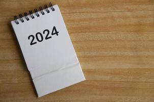 Year 2024 text on white table calendar with customizable space for text or ideas. Copy space and calendar concept. photo