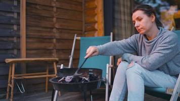 Woman makes a barbecue on the terrace outdoors. Home rest in warm evening video