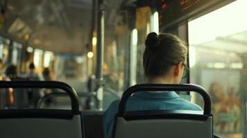 Woman with glasses in a tram looking out the window. City, urban, transportation