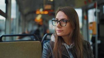 offentlig transport. kvinna i glasögon i spårvagn använder sig av smartphone, långsam rörelse video