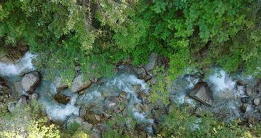 Top down view a mountain river flowing among large stones video