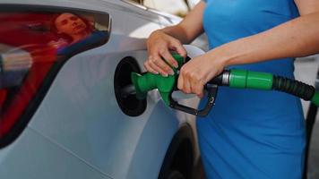 mujer inserta un combustible pistola en un gas tanque a repostar un coche video