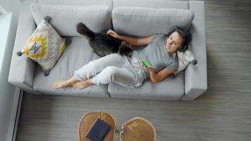 ontspannen vrouw in hoofdtelefoons met smartphone met groen mock-up scherm video