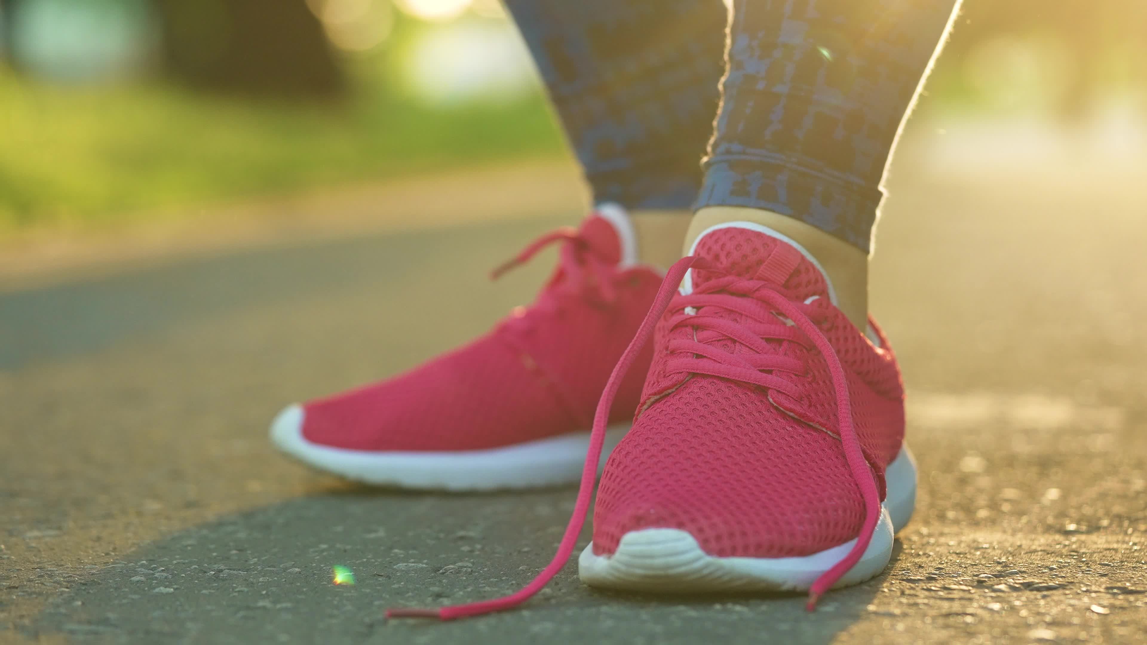 Compañero Portavoz Espere Woman tying shoelaces while jogging or walking at sunset. Slow motion  21569243 Stock Video at Vecteezy