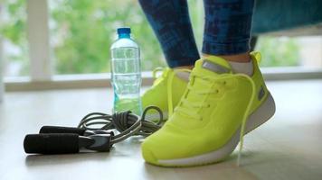 Woman tying shoelaces on sneakers going for training or jogging video