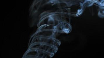 resumen fumar sube arriba en hermosa remolinos en un negro antecedentes. lento movimiento video