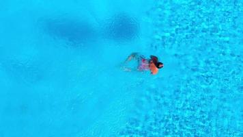 Aerial view as a man dives into the pool and swims. video