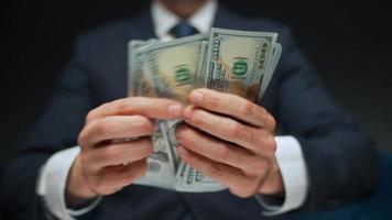 Formally dressed man counting US Dollar bills, close-up. video