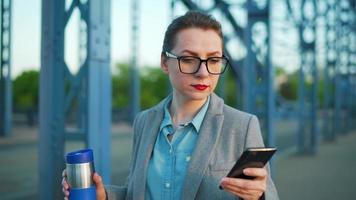 Woman in a coat, walking around the city in the early morning, drinking coffee video