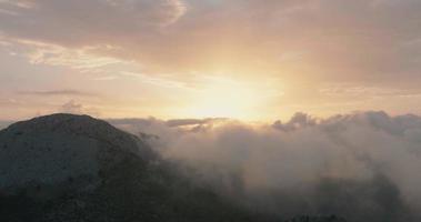 Flying in mountainous terrain at cloud level at sunset. Spain video