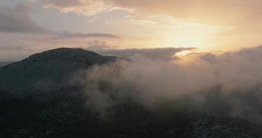 Flying in mountainous terrain at cloud level at sunset. Spain video