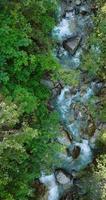 verticaal video. top naar beneden visie een berg rivier- vloeiende tussen groot stenen video