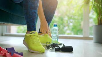 Woman tying shoelaces on sneakers going for training or jogging video