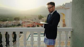 Man in a jacket and underwear negotiates at home on the terrace of a villa video