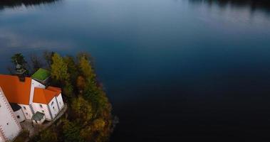 aéreo ver de lago desangrado y el isla en el medio de él, Eslovenia video