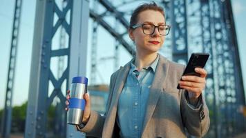 vrouw in een jas, wandelen in de omgeving van de stad in de vroeg ochtend, drinken koffie video